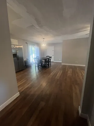 a view of empty room with wooden floor and a window