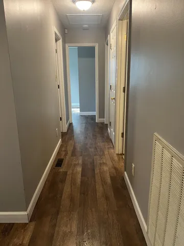 a view of a hallway with wooden floor and staircase