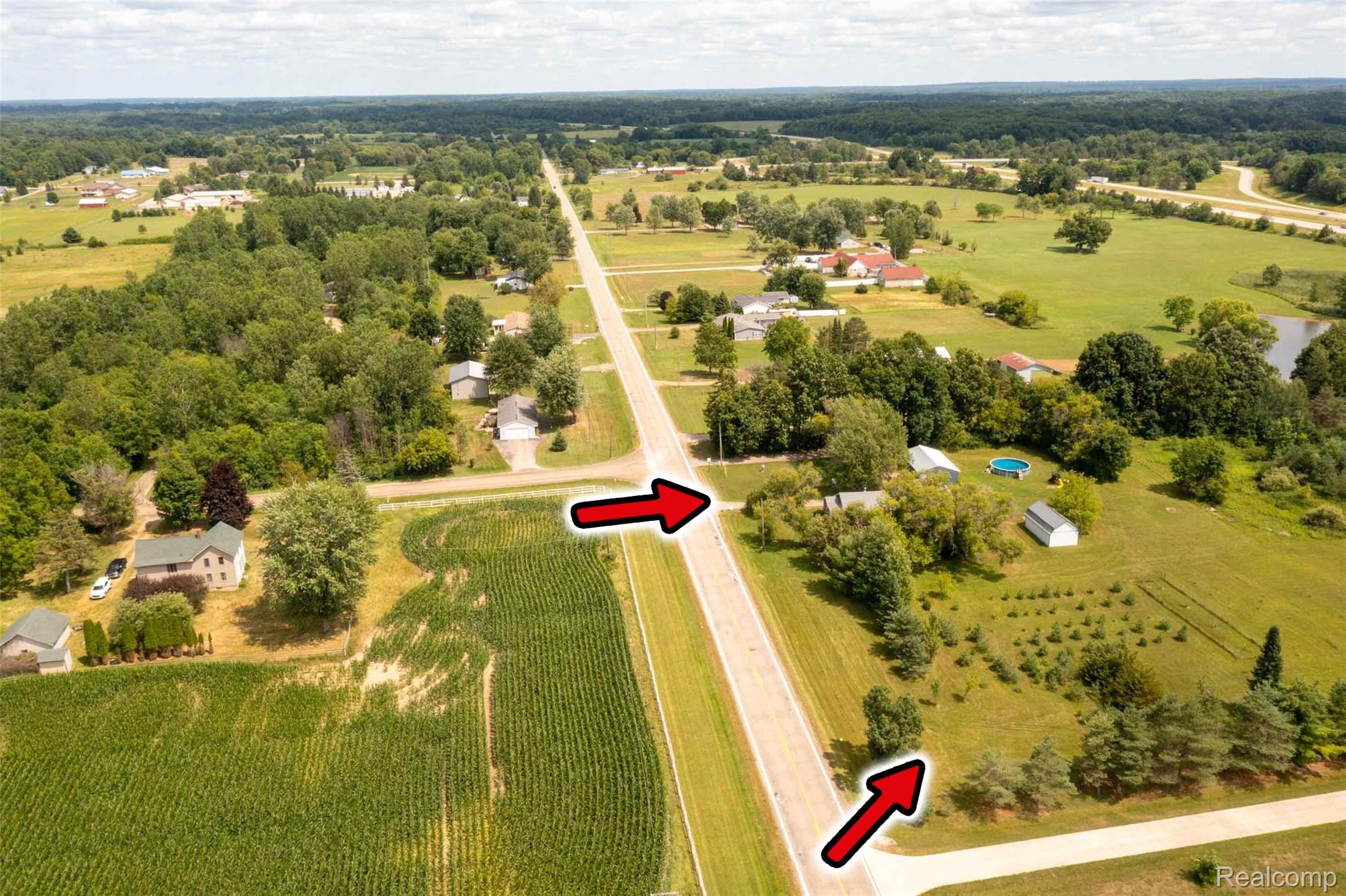 5761 Genesee Road Lapeer, MI 48446 - Photo 34 of 52 Expansive rural landscape featuring a paved road, scattered residential properties, mature trees, and agricultural fields