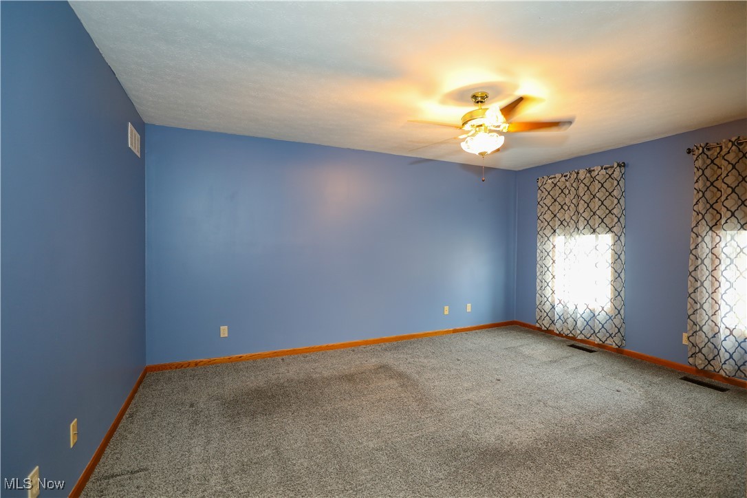 12565 Alpha Road Hiram, OH 44234 - Photo 29 of 50 Carpeted empty room with baseboards, visible vents, and ceiling fan
