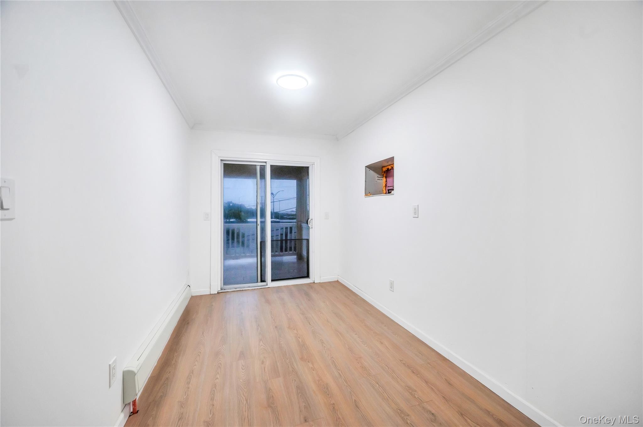 21 Van Brunt Road Queens, NY 11693 - Photo 13 of 17 Empty room featuring crown molding and light wood-style flooring