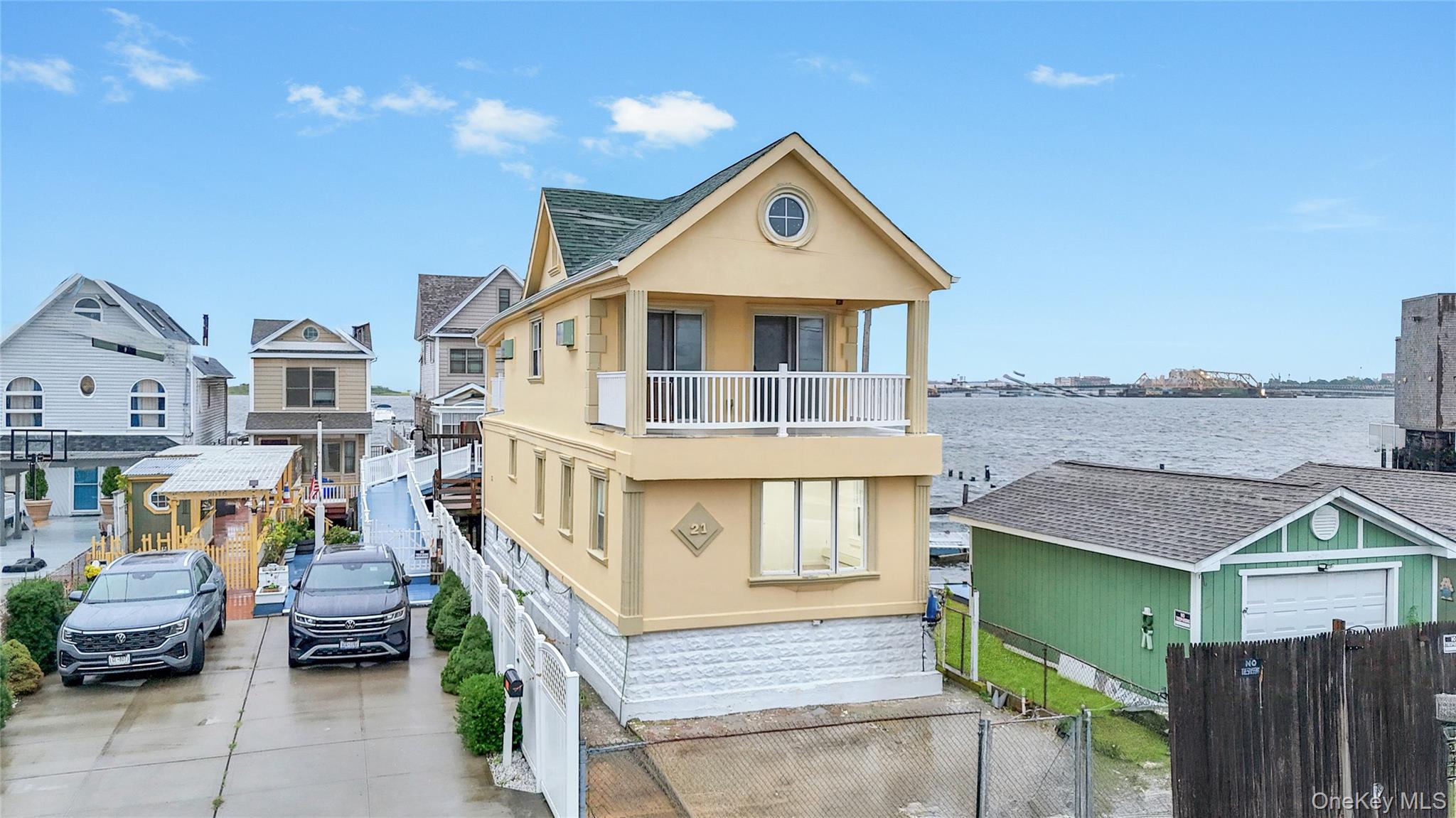 21 Van Brunt Road Queens, NY 11693 - Photo 15 of 17 View of front of home featuring a balcony, stucco siding, a water view, and driveway