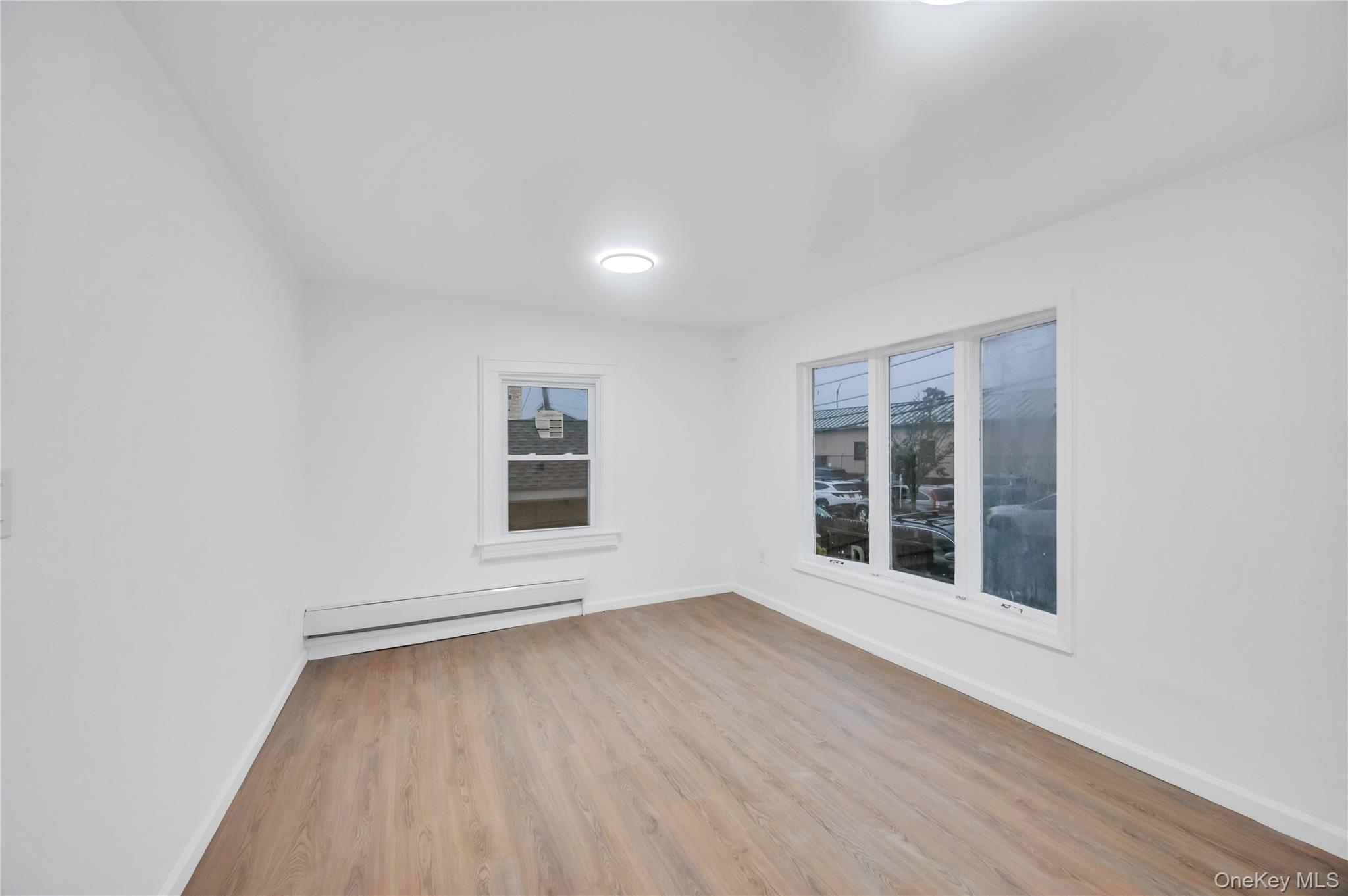 21 Van Brunt Road Queens, NY 11693 - Photo 9 of 17 Spare room featuring light wood finished floors and baseboard heating