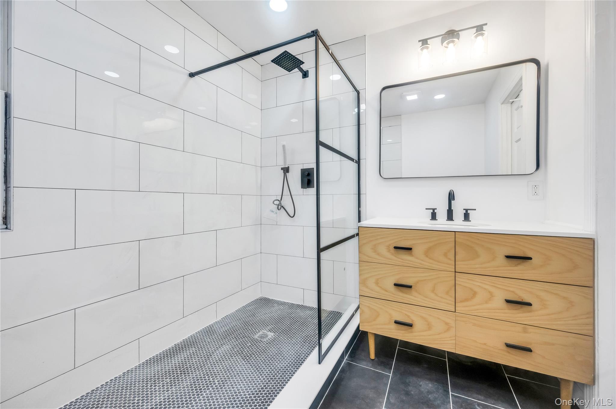 21 Van Brunt Road Queens, NY 11693 - Photo 10 of 17 Bathroom featuring a shower stall, vanity, dark tile patterned floors, and recessed lighting