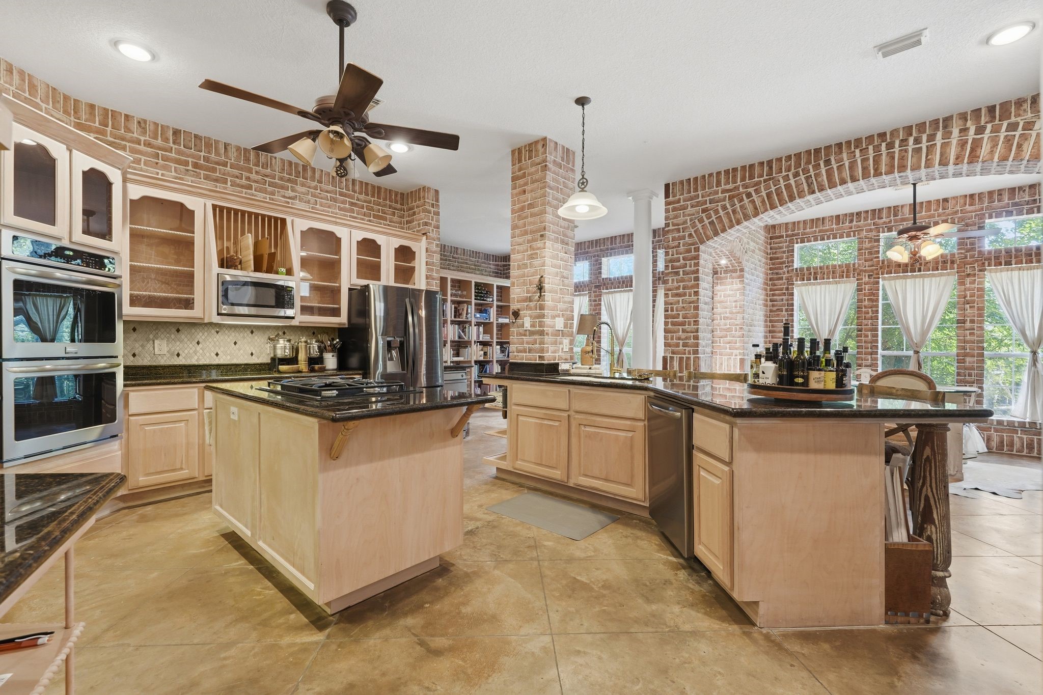 25014 Northampton Terrace Drive Spring, TX 77389 - Photo 8 of 41 The kitchen designed for the chef in your family! The center island provides a gas cooktop and prep area. Double ovens convenient for large dinner parties. Solid wood cabinetry with glass front to show off your favorite dishes & glassware