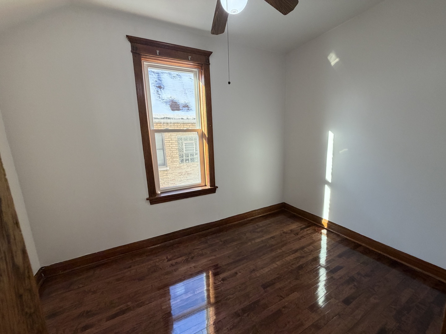2624 West Walton Street, Unit 1 Chicago, IL 60622 - Photo 21 of 23 an empty room with wooden floor cabinet and windows