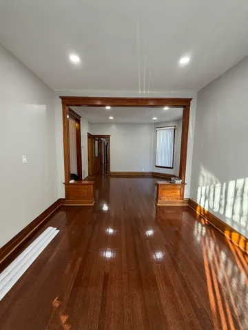 a view of an empty room with glass door and windows