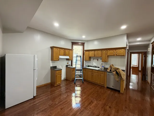 a kitchen with a wooden floor kitchen counter top space and stainless steel appliances