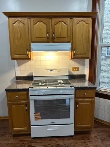 a stove top oven sitting inside of a kitchen