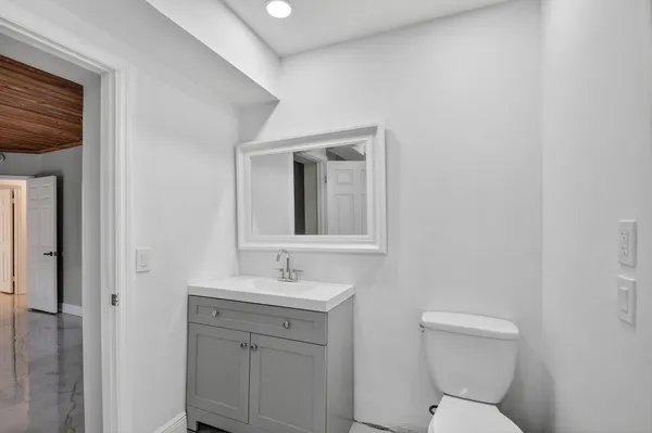 a bathroom with a granite countertop bathtub shower sink vanity and toilet