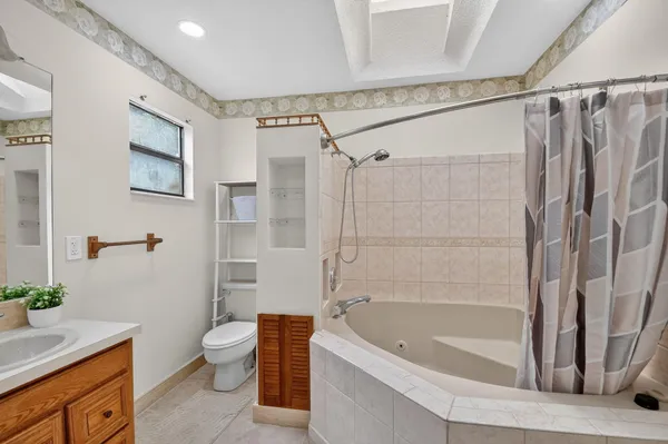 a view of an empty room with wooden floor and windows