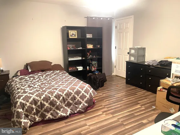 a bedroom with a bed and dresser with mirror