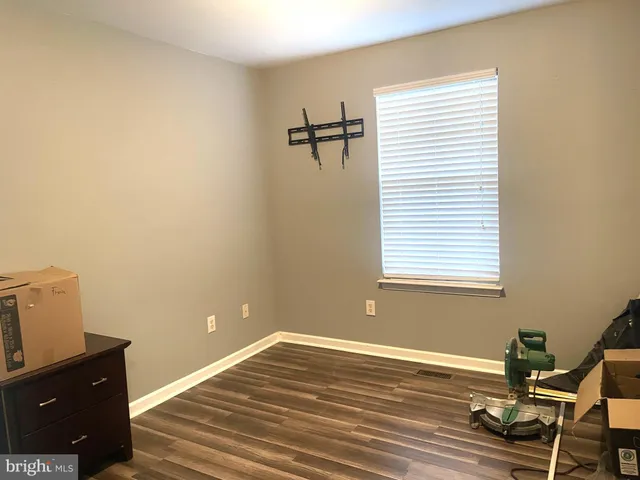 a view of a room with a window and wooden floor