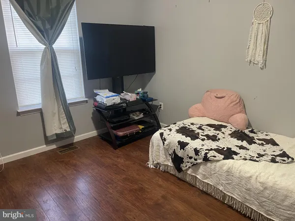 a bedroom with bed and wooden floor