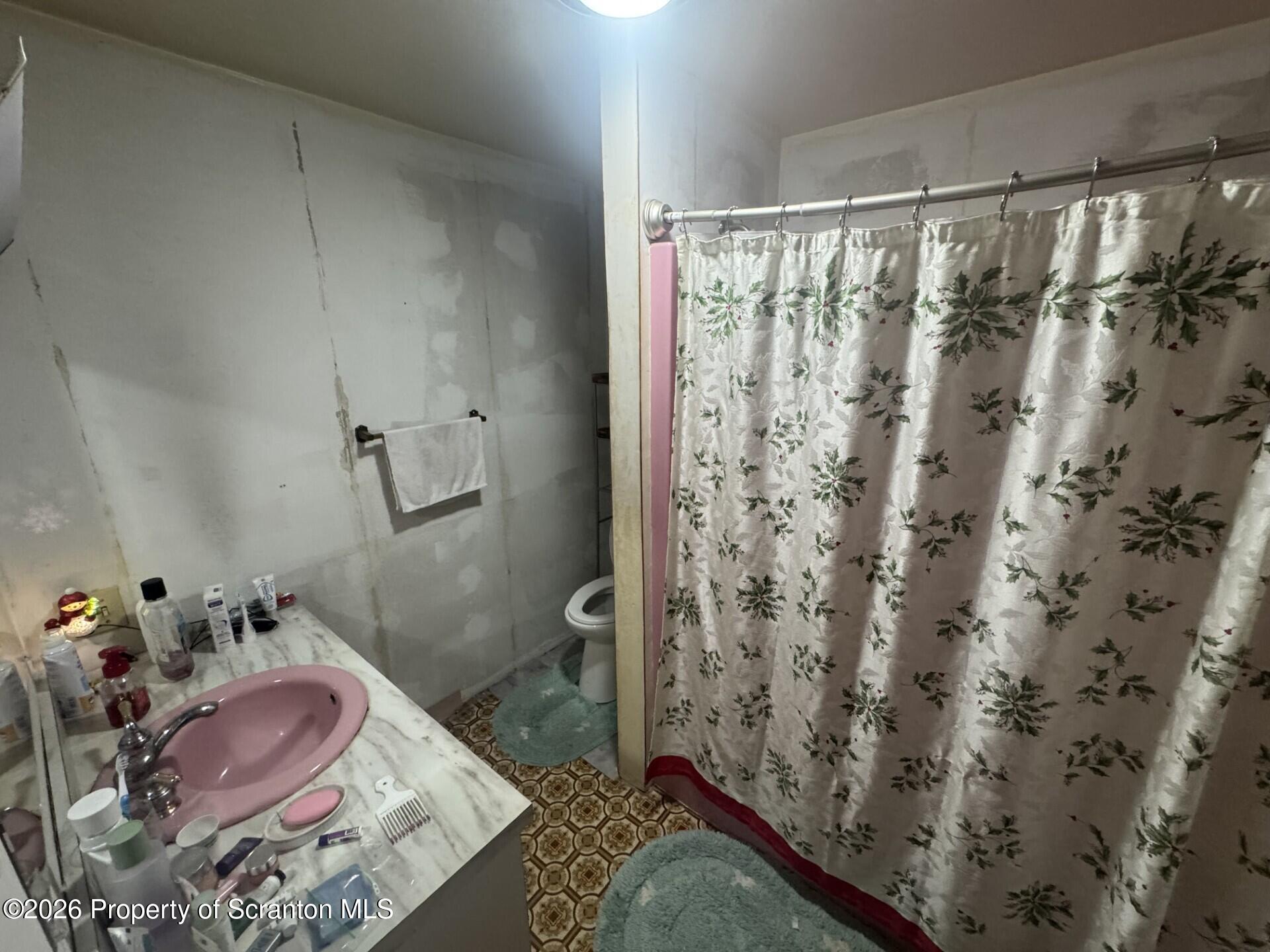 16 Maffett Street Plains, PA 18705 - Photo 13 of 19 a bathroom with a granite countertop sink and a shower curtain