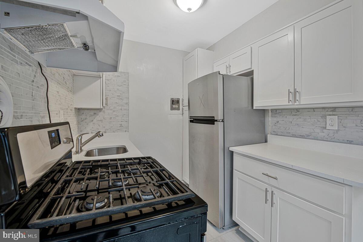 107 Joliet Street Washington, DC 20032 - Photo 11 of 52 a kitchen with white cabinets and appliances
