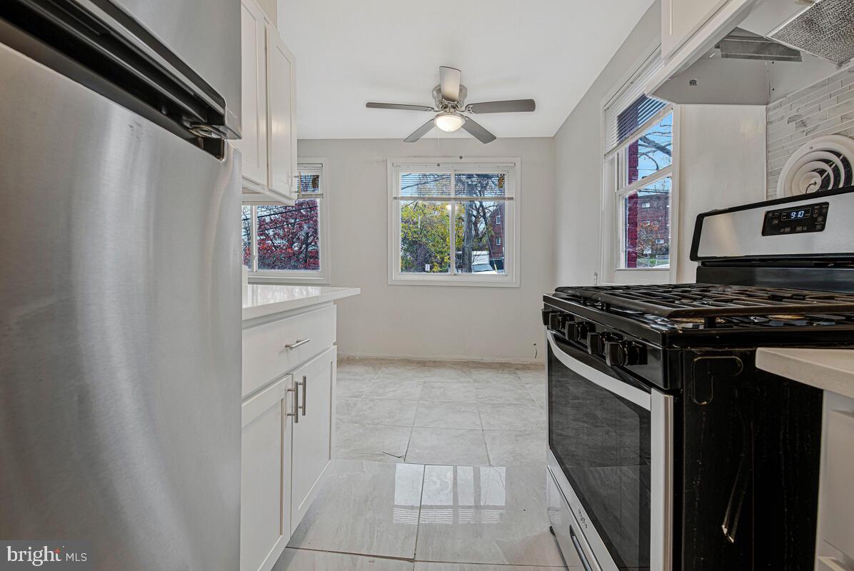 107 Joliet Street Washington, DC 20032 - Photo 13 of 52 a kitchen with stainless steel appliances a sink stove and cabinets