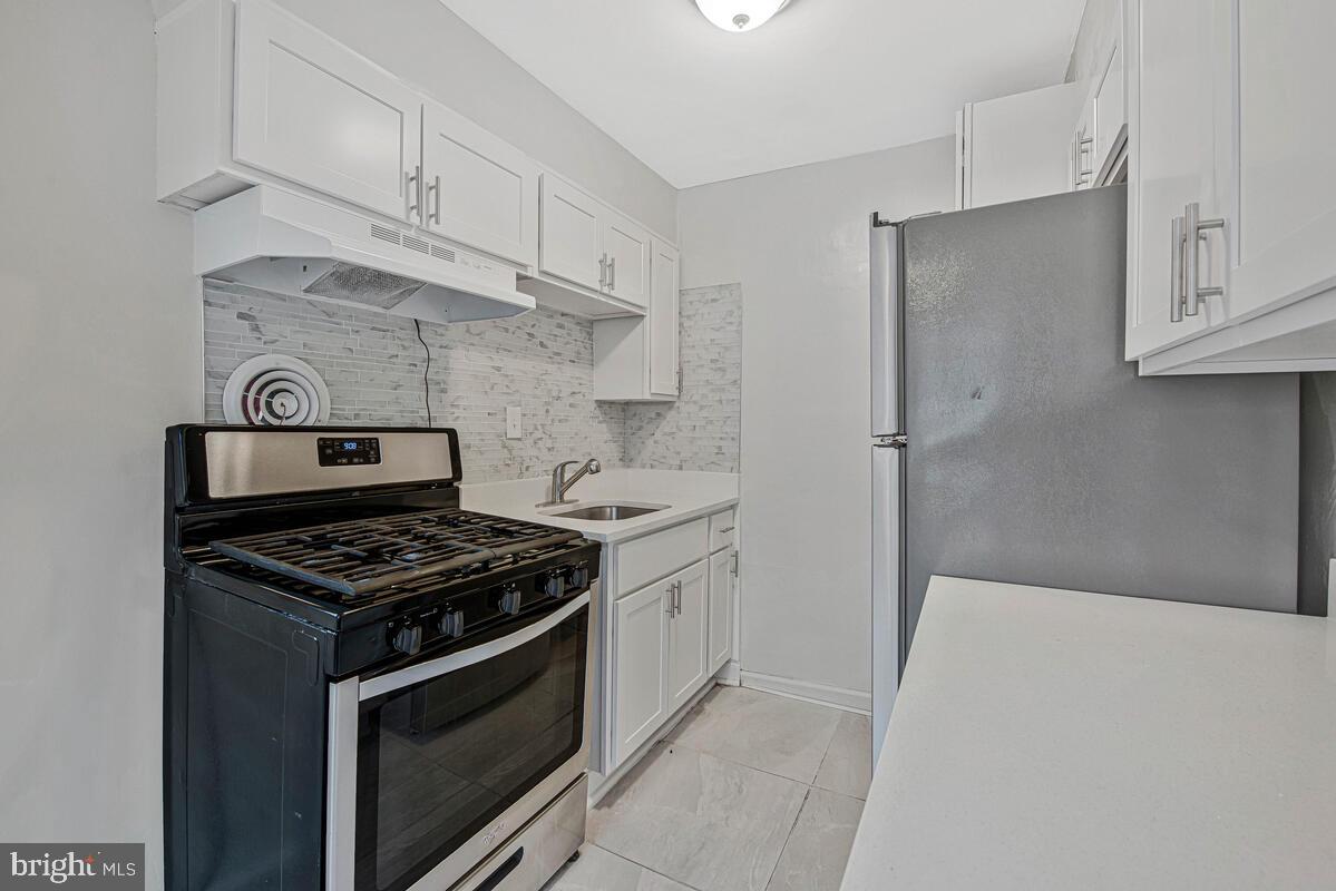 107 Joliet Street Washington, DC 20032 - Photo 10 of 52 a kitchen with stainless steel appliances a stove and white cabinets