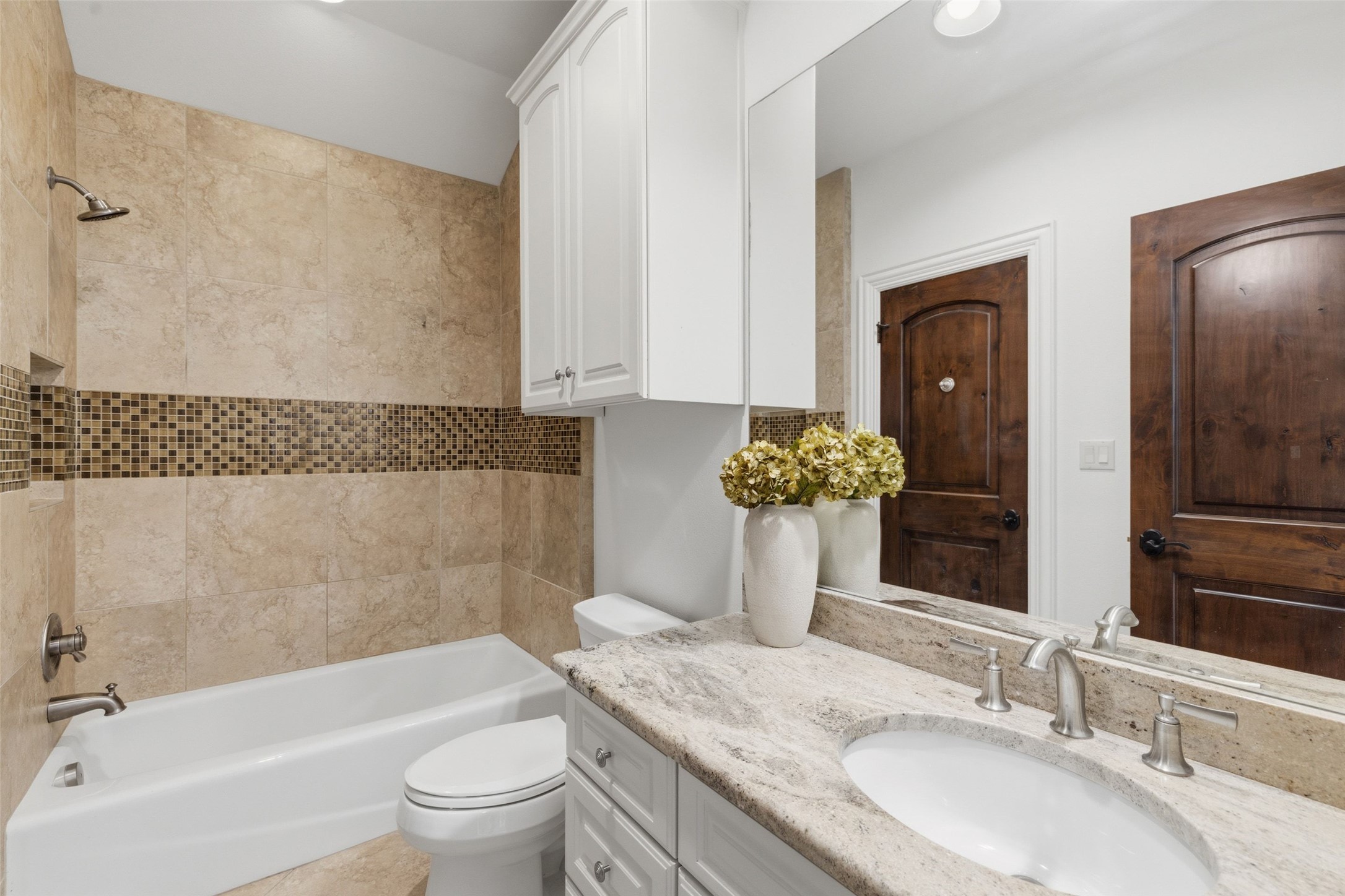 1414 The High Road Austin, TX 78746 - Photo 27 of 40 A well-appointed bathroom features a bath with a shower head, vanity with a sleek sink, and generous storage options.