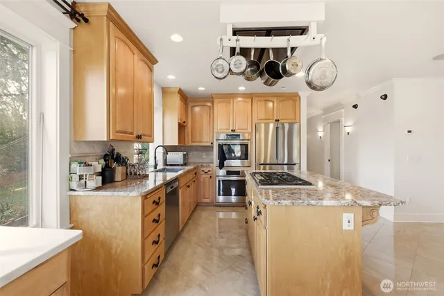 a kitchen with stainless steel appliances granite countertop a sink a stove top oven and cabinets
