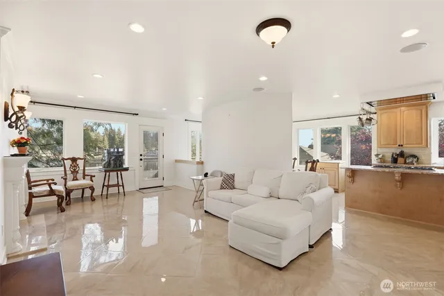 a living room with couches and kitchen view with wooden floor