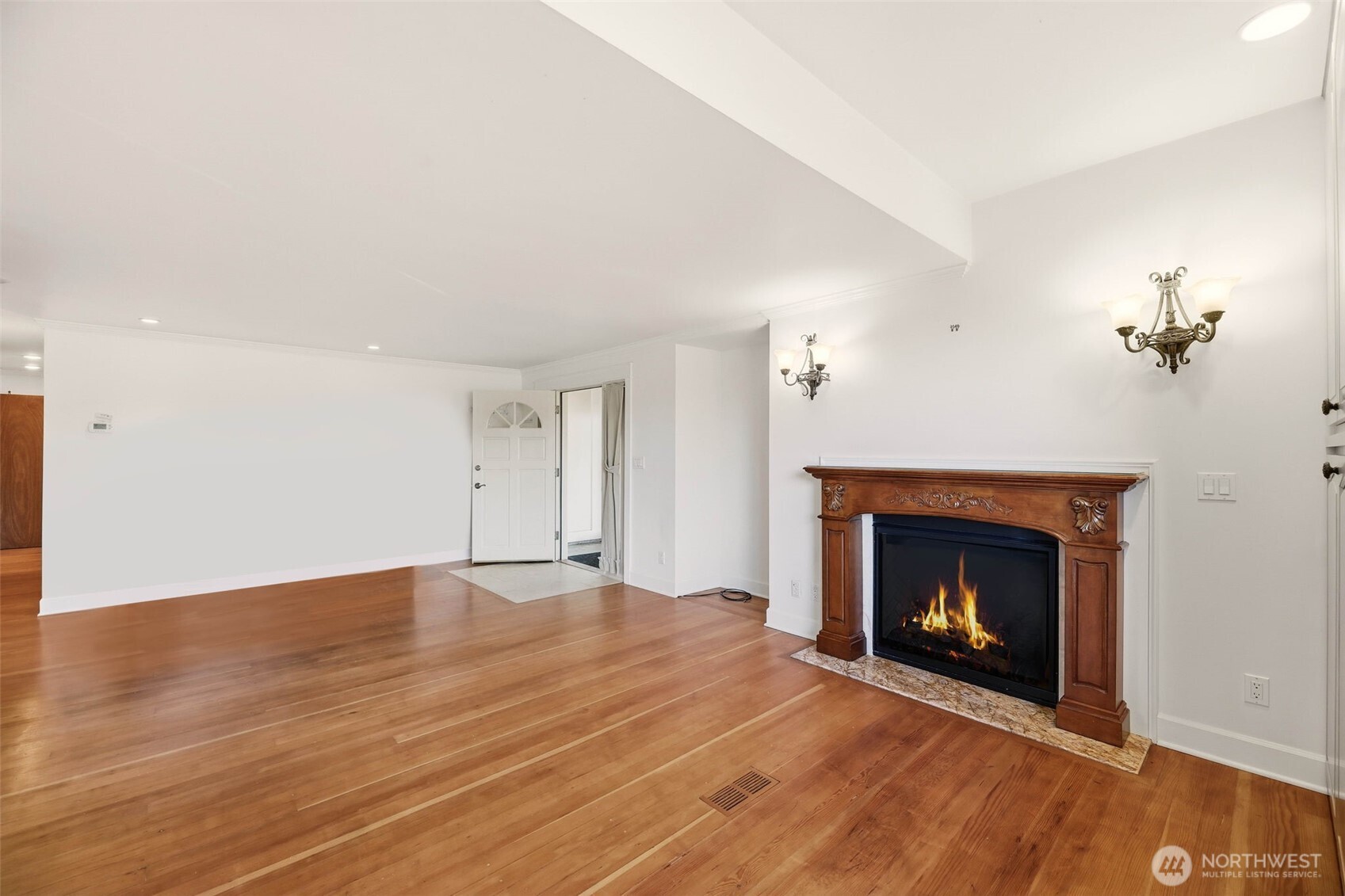 3821 Shelby Road Lynnwood, WA 98087 - Photo 24 of 40 an empty room with wooden floor fireplace cabinet and windows