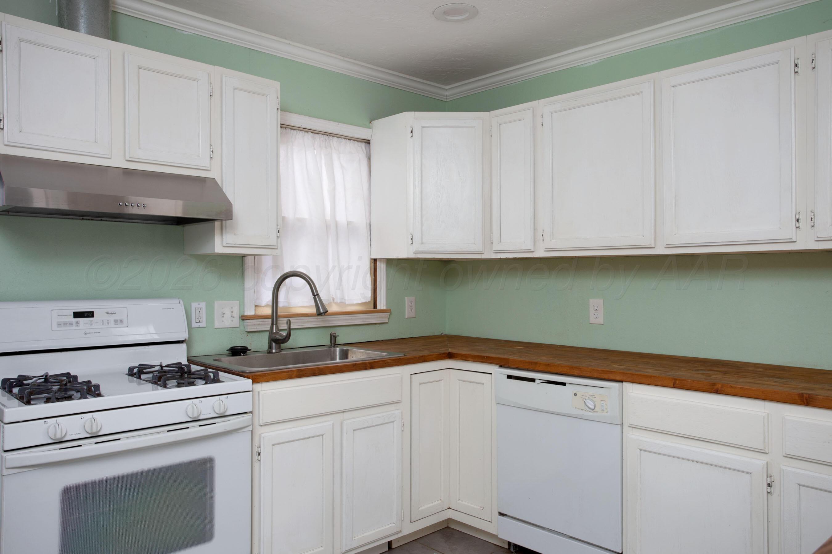 1616 South Travis Street Amarillo, TX 79102 - Photo 12 of 26 a kitchen with stainless steel appliances granite countertop white cabinets a sink and dishwasher