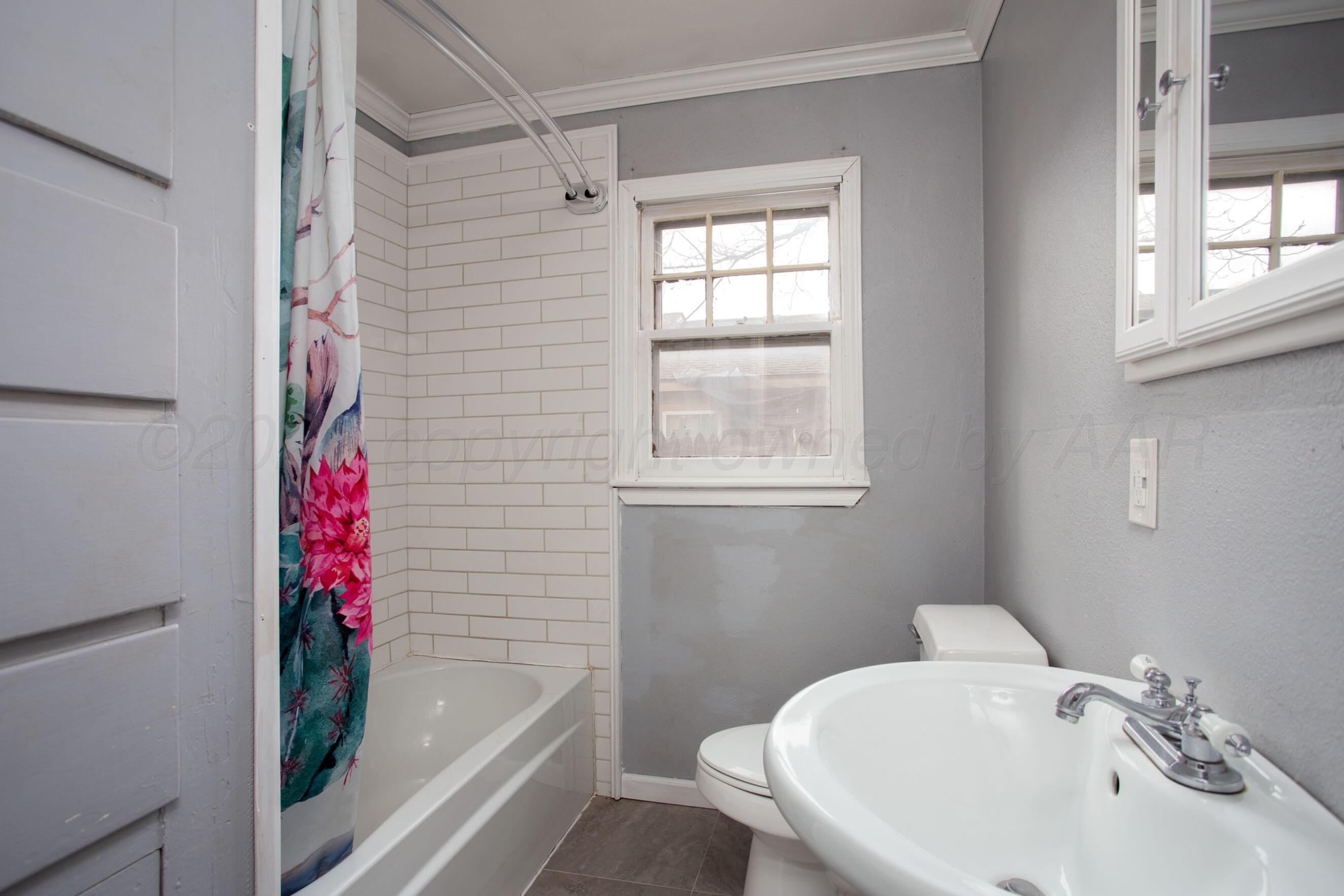 1616 South Travis Street Amarillo, TX 79102 - Photo 18 of 26 a bathroom with a sink and a bathtub