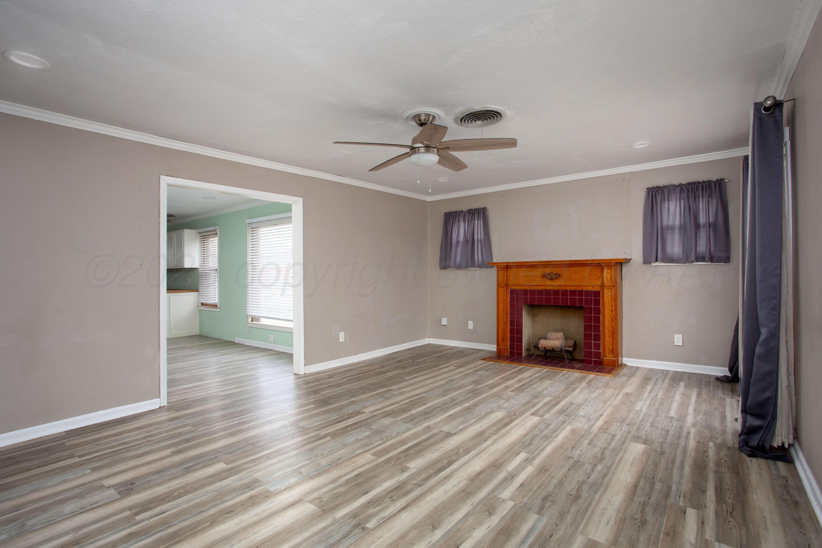 1616 South Travis Street Amarillo, TX 79102 - Photo 2 of 26 wooden floor fireplace and windows in an empty room
