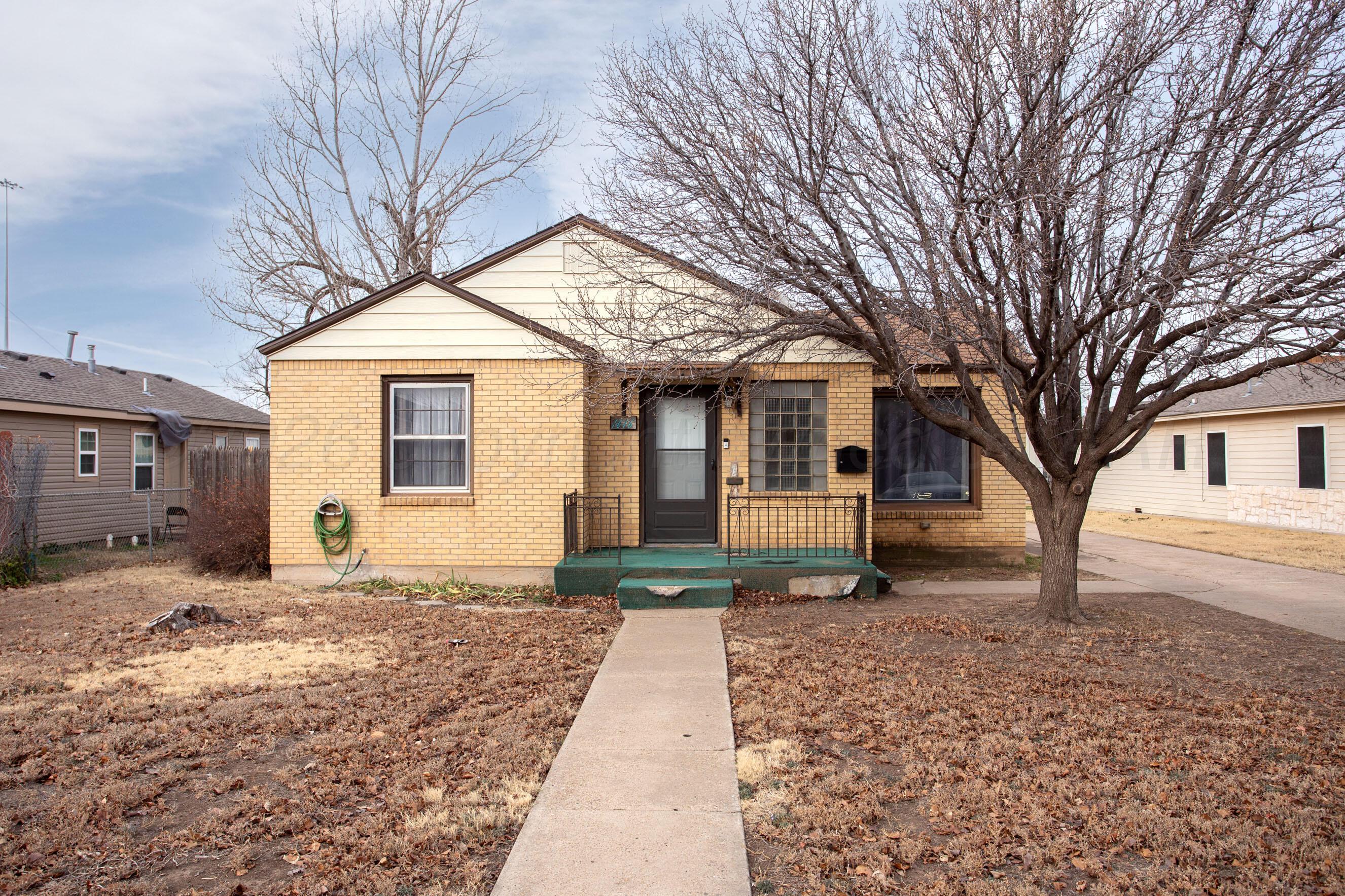 1616 South Travis Street Amarillo, TX 79102 - Photo 4 of 26 a front view of a house with a yard and garage