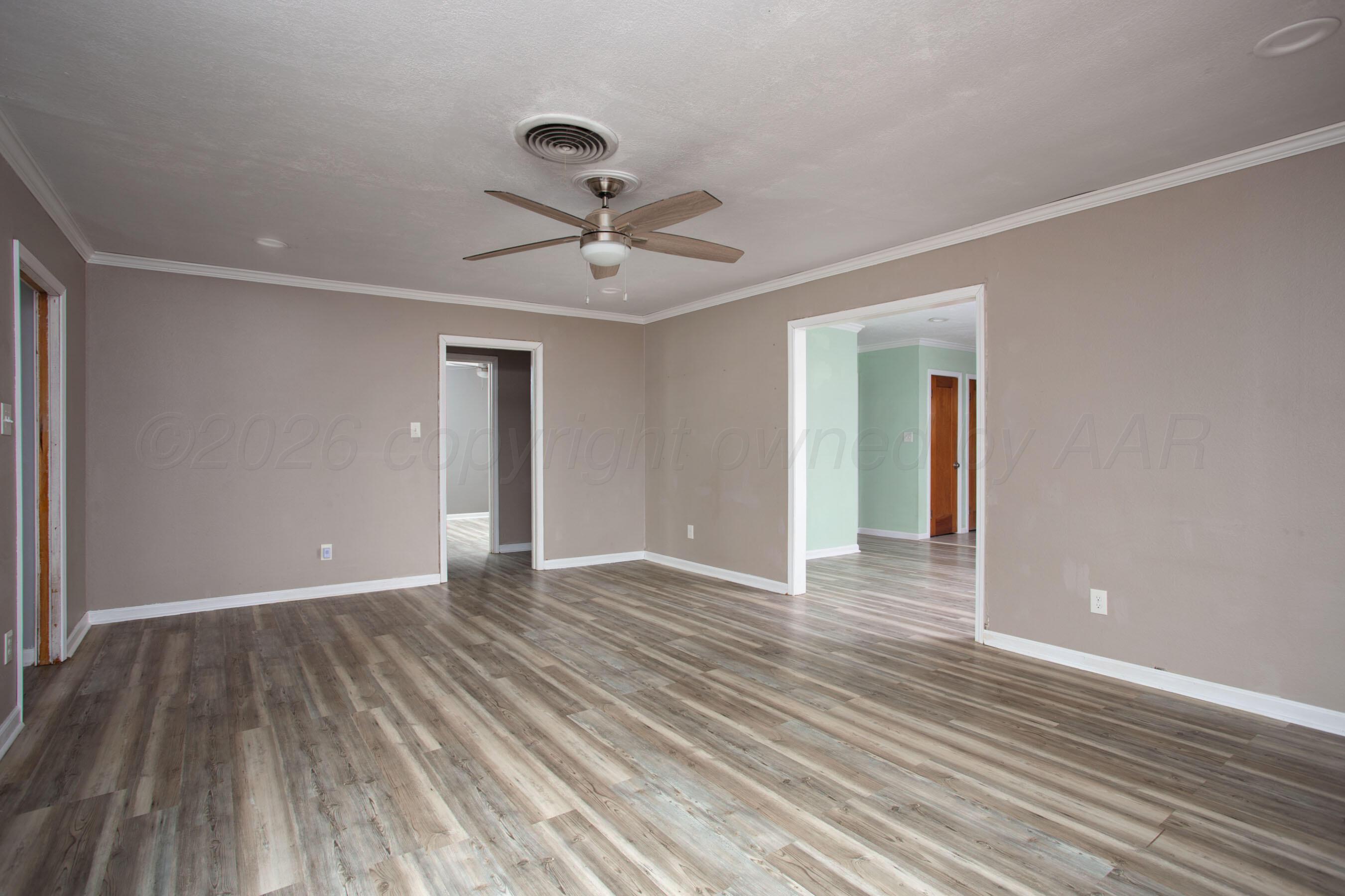 1616 South Travis Street Amarillo, TX 79102 - Photo 8 of 26 a view of an empty room with wooden floor and a ceiling fan
