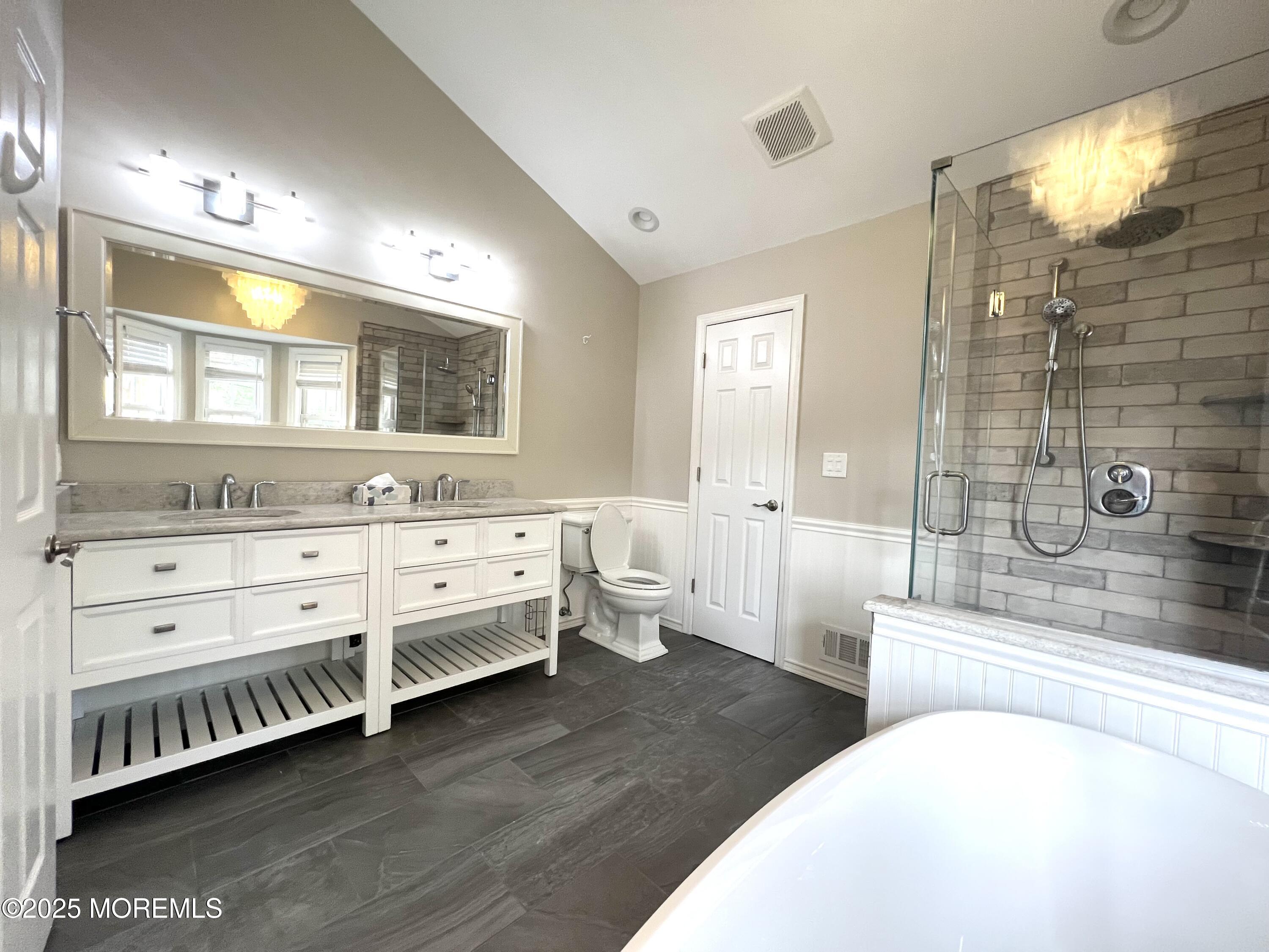 21 Durant Avenue, Unit 145 Holmdel, NJ 07733 - Photo 15 of 25 a spacious bathroom with double vanity a mirror a bathtub and a shower