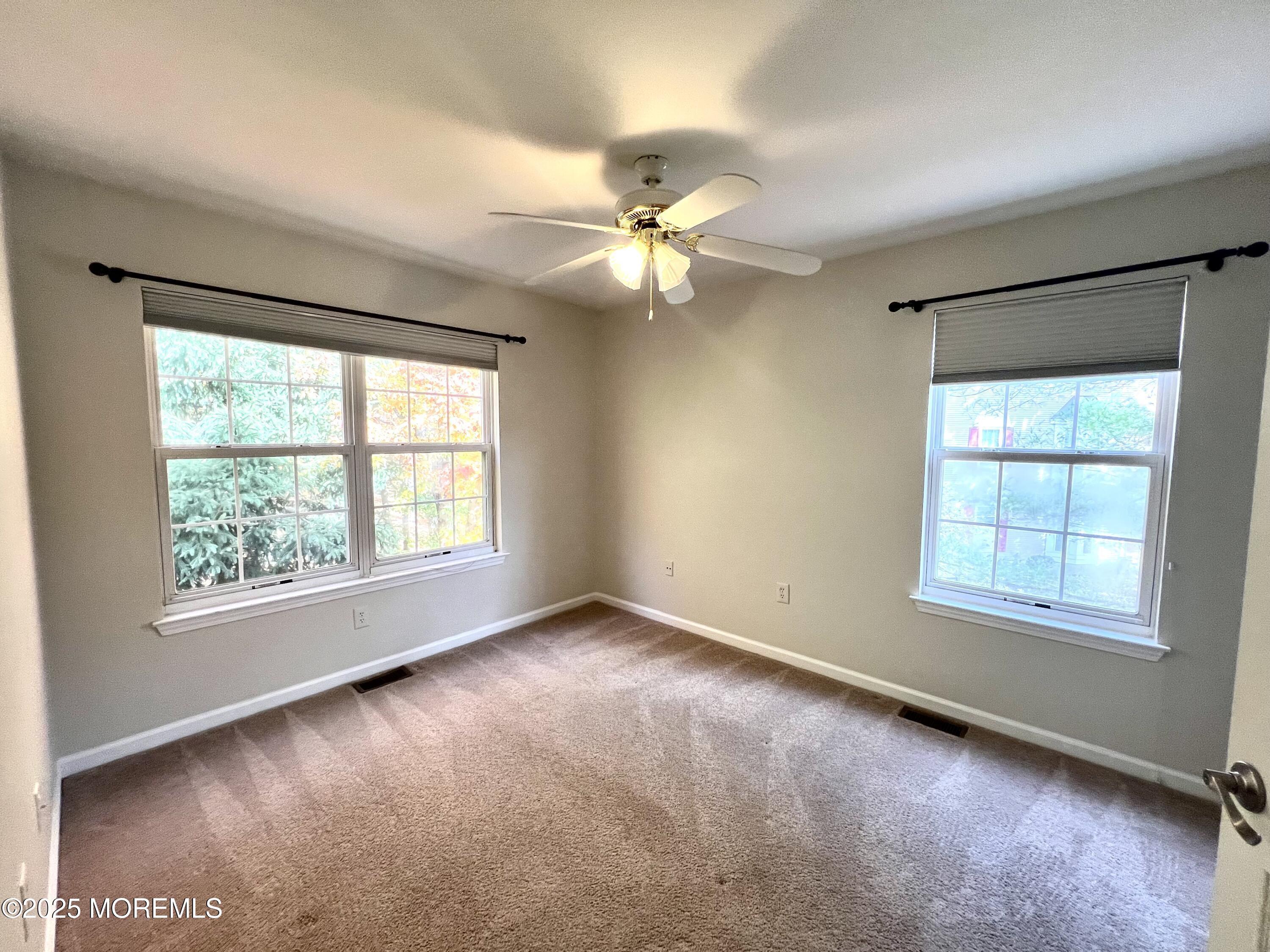 21 Durant Avenue, Unit 145 Holmdel, NJ 07733 - Photo 21 of 25 an empty room with a window and a ceiling fan