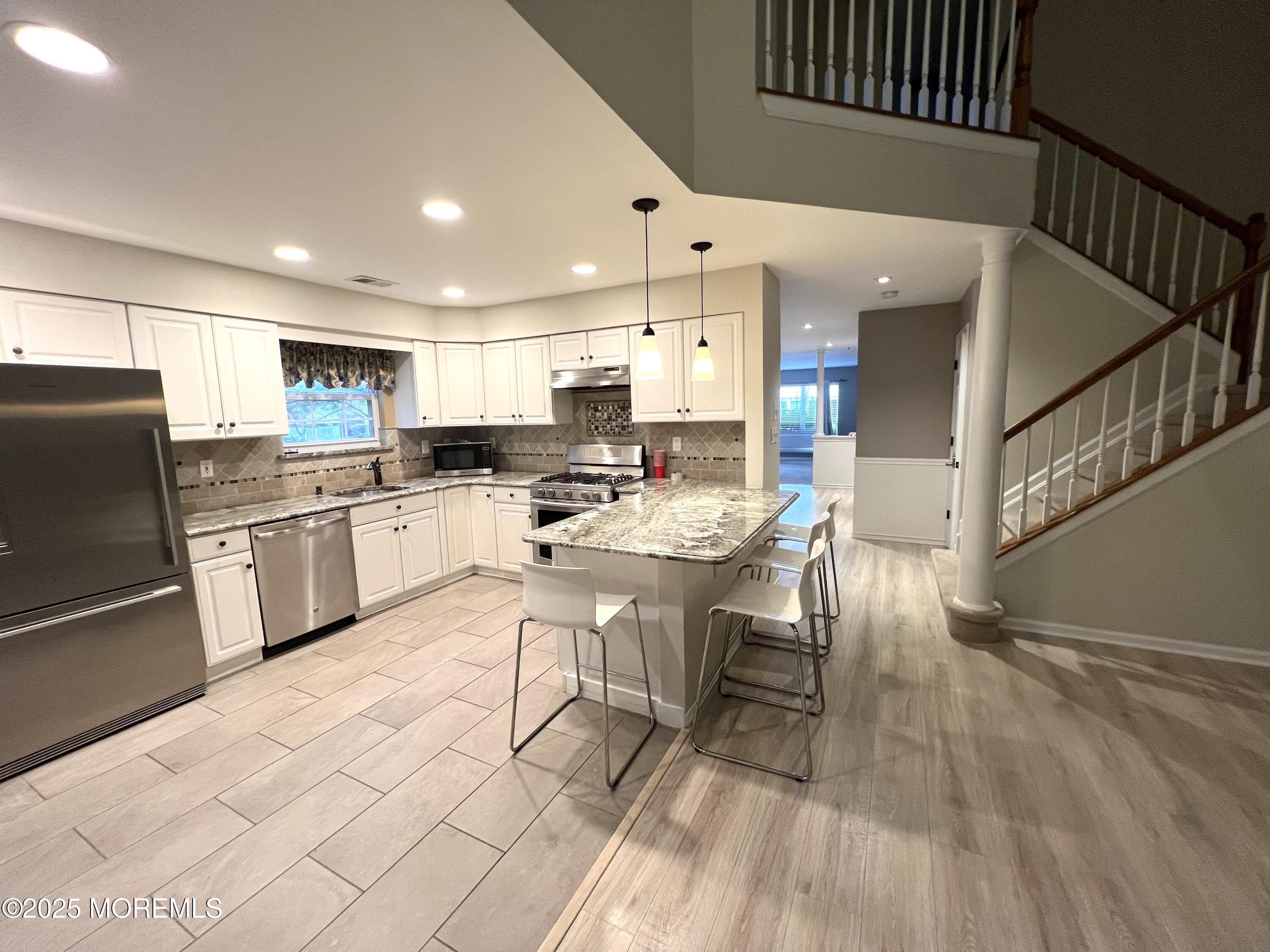 21 Durant Avenue, Unit 145 Holmdel, NJ 07733 - Photo 7 of 25 a kitchen with a sink a counter top space stainless steel appliances and cabinets