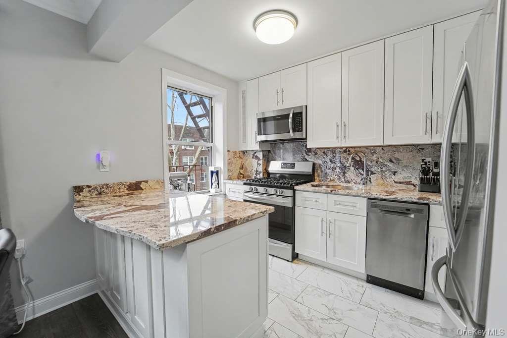 141-35 78th Road, Unit 2M Queens, NY 11367 - Photo 4 of 11 a kitchen with stainless steel appliances granite countertop a sink stove and refrigerator