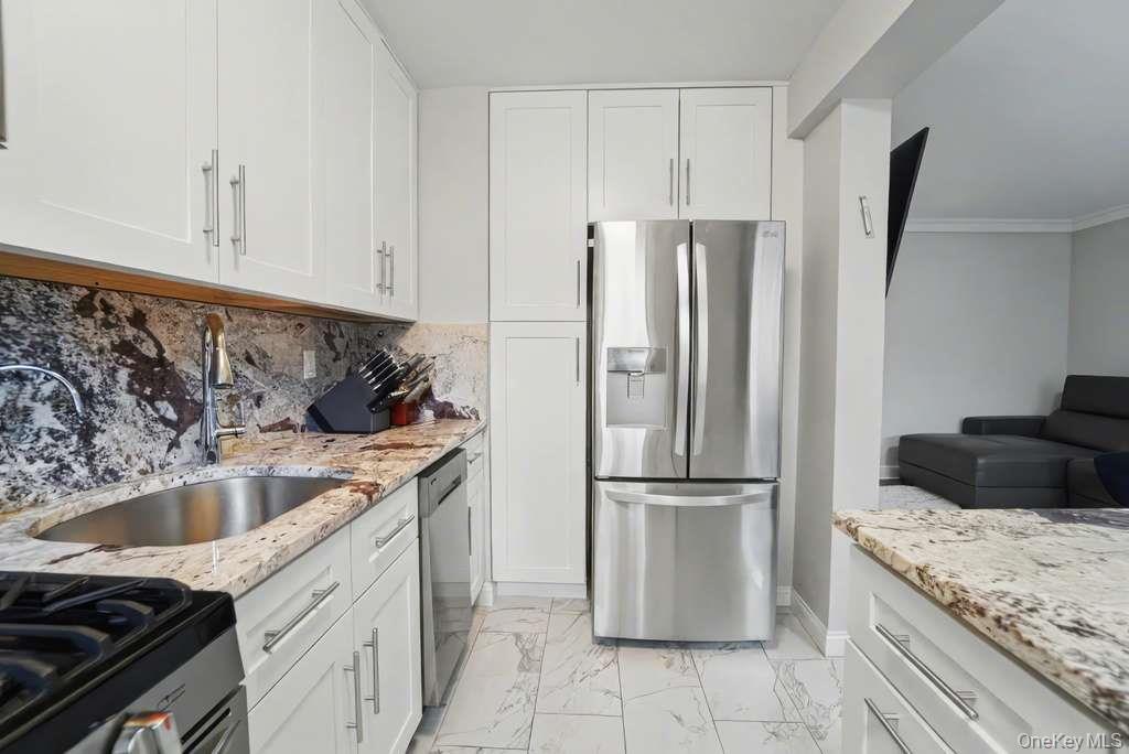 141-35 78th Road, Unit 2M Queens, NY 11367 - Photo 5 of 11 a kitchen with a refrigerator sink and cabinets