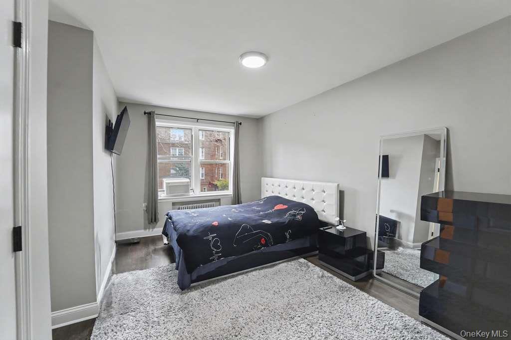 141-35 78th Road, Unit 2M Queens, NY 11367 - Photo 8 of 11 a living room with a bed furniture and a window