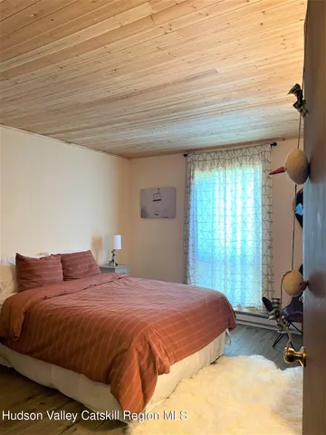 a bedroom with a bed window and chair