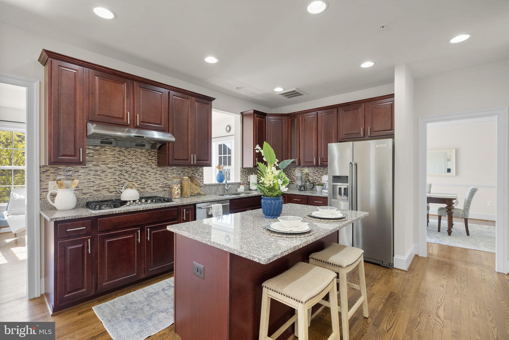 22403 Newcut Road Clarksburg, MD 20871 - Photo 14 of 78 a kitchen with stainless steel appliances granite countertop a refrigerator a sink dishwasher a stove and a dining table with wooden floor