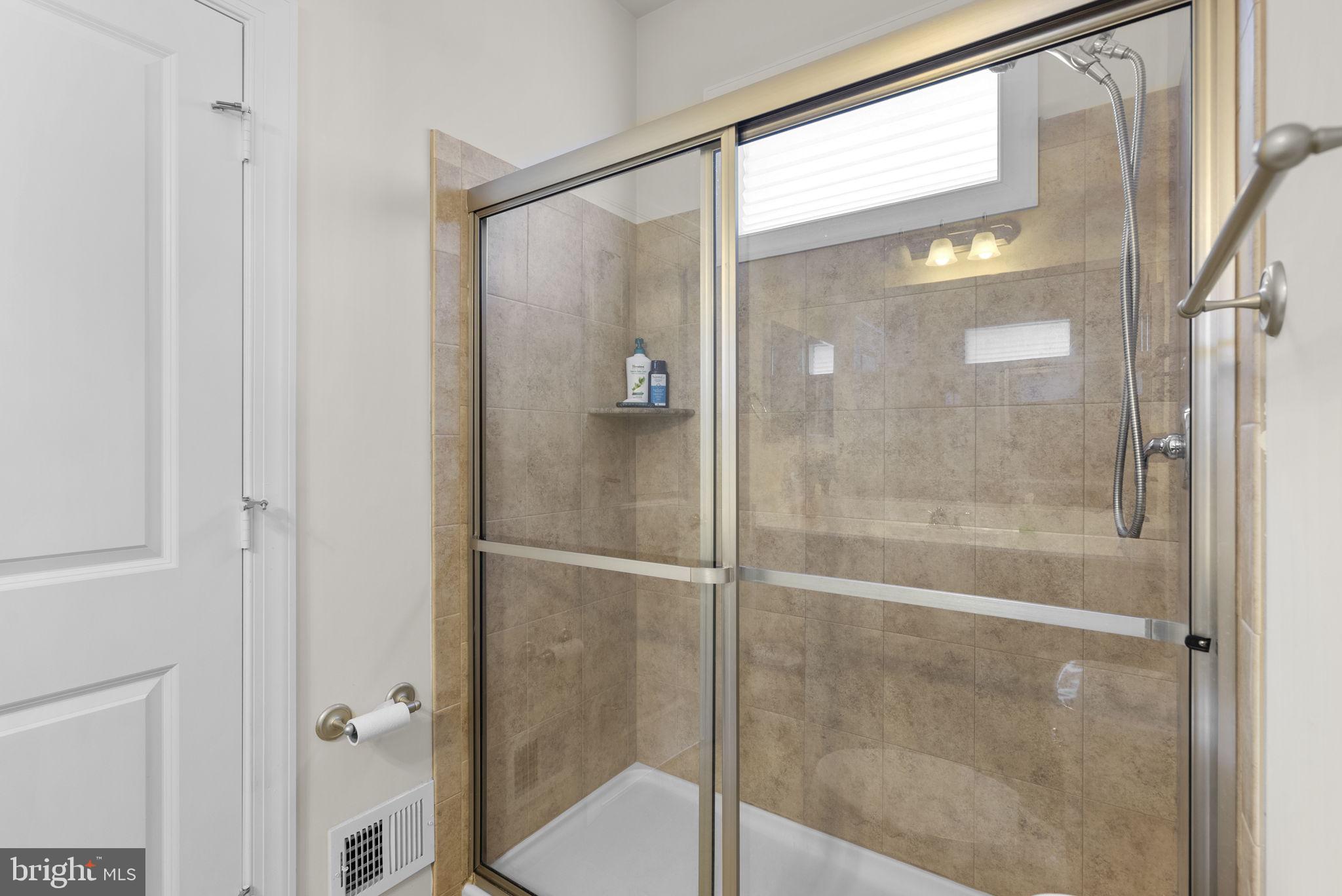 22403 Newcut Road Clarksburg, MD 20871 - Photo 56 of 78 a bathroom with a glass shower door