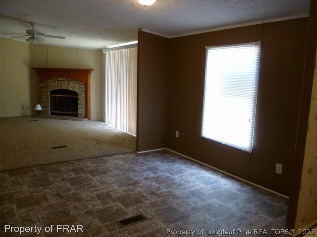 903 Poole Road Raeford, NC 28376 - Photo 6 of 27 an empty room with windows and fireplace