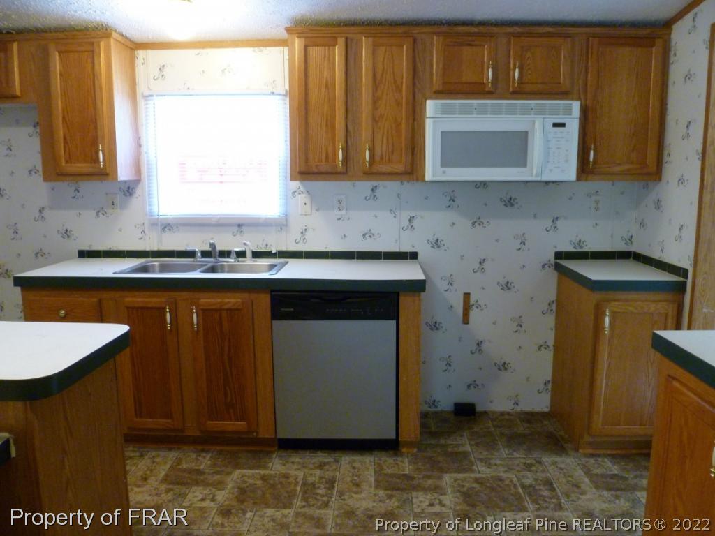 903 Poole Road Raeford, NC 28376 - Photo 10 of 27 a kitchen with a sink cabinets and wooden floor