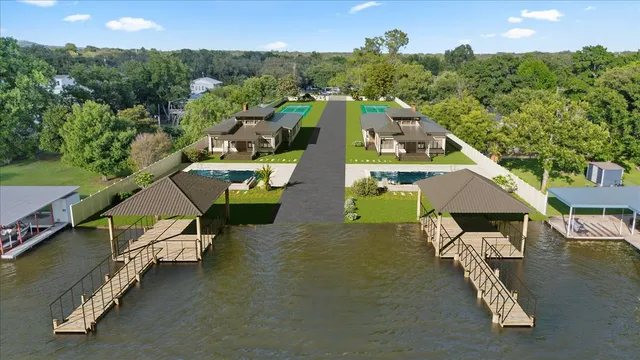 an aerial view of a house with swimming pool and large trees