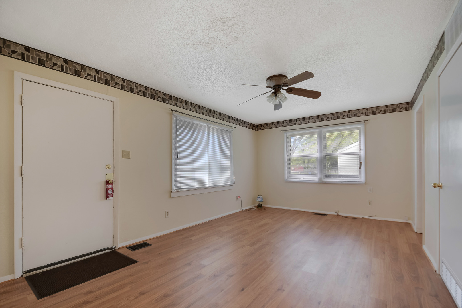 116 Louis Road Joliet, IL 60433 - Photo 3 of 12 a view of an empty room with a window and wooden floor