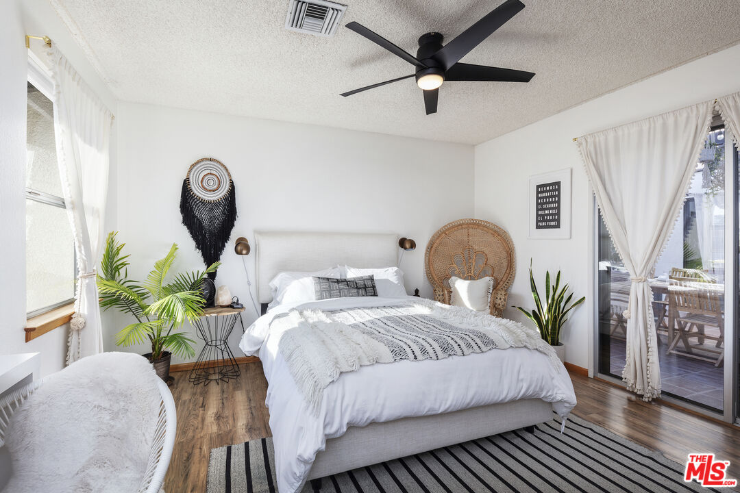 56434 Cobalt Road Yucca Valley, CA 92284 - Photo 26 of 75 a bedroom with a bed table flowerpot and a potted plant