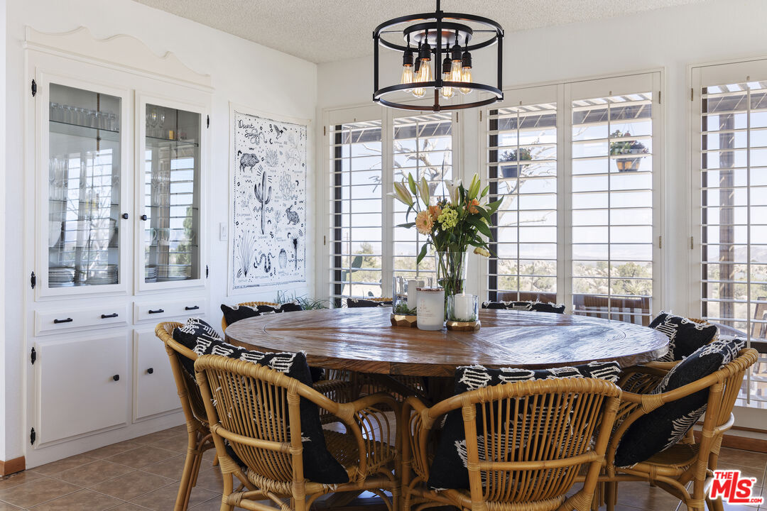 56434 Cobalt Road Yucca Valley, CA 92284 - Photo 39 of 75 a dining room with furniture a rug and wooden floor