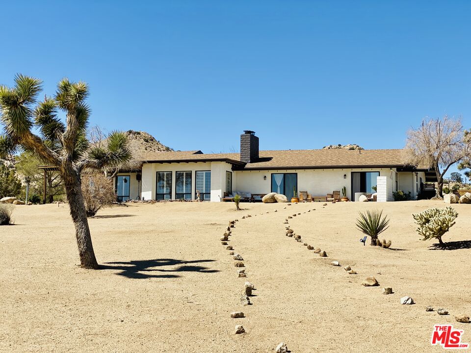 56434 Cobalt Road Yucca Valley, CA 92284 - Photo 62 of 75 a front view of a house with a yard covered with snow in the background