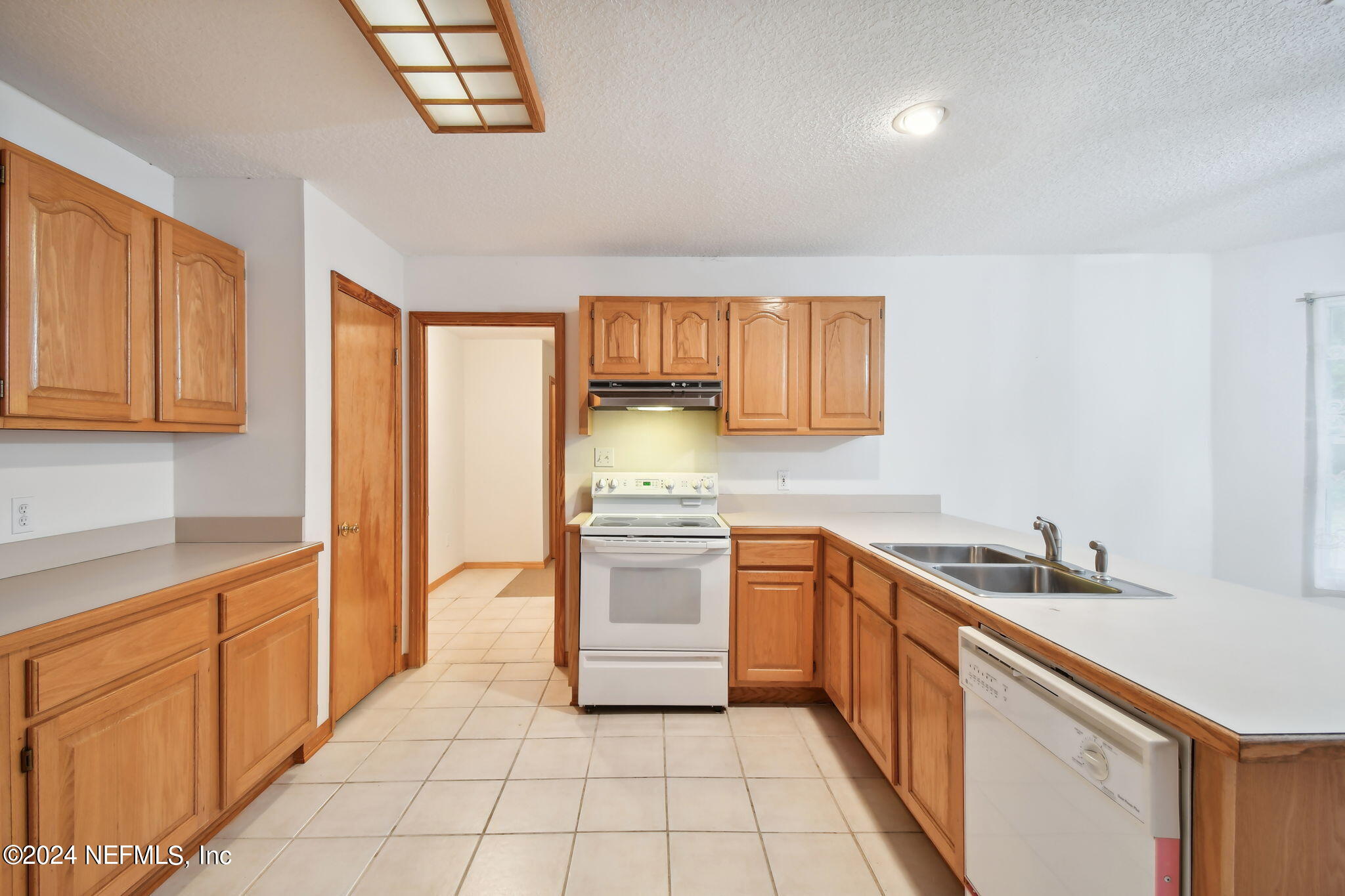 36068 J W Elliott Road Callahan, FL 32011 - Photo 21 of 54 a kitchen with stainless steel appliances granite countertop a sink and dishwasher a stove with wooden cabinets