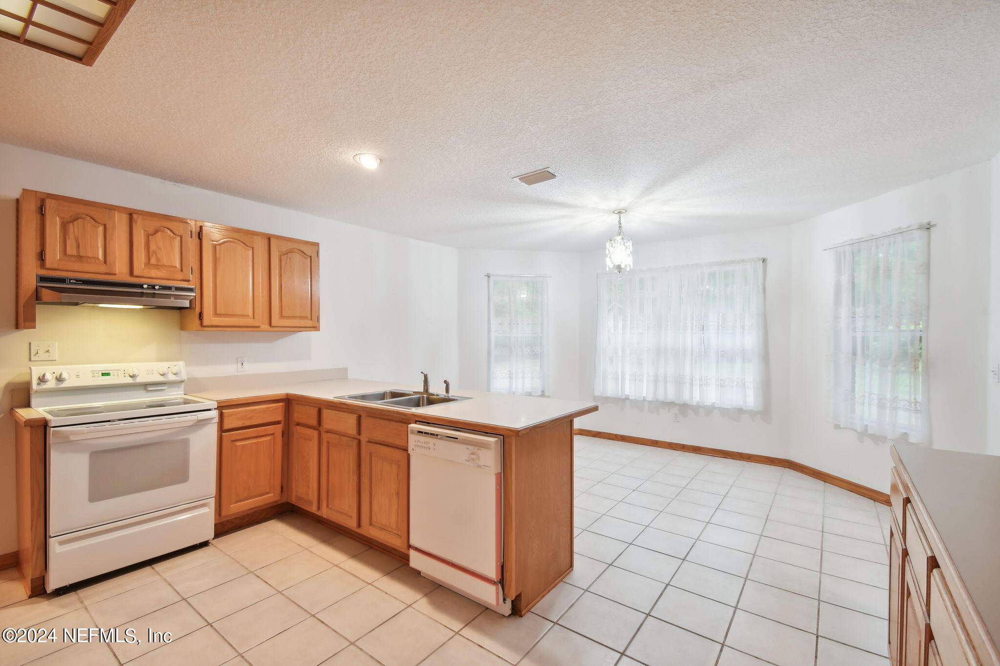 36068 J W Elliott Road Callahan, FL 32011 - Photo 22 of 54 a kitchen with stainless steel appliances granite countertop a stove a sink and a refrigerator