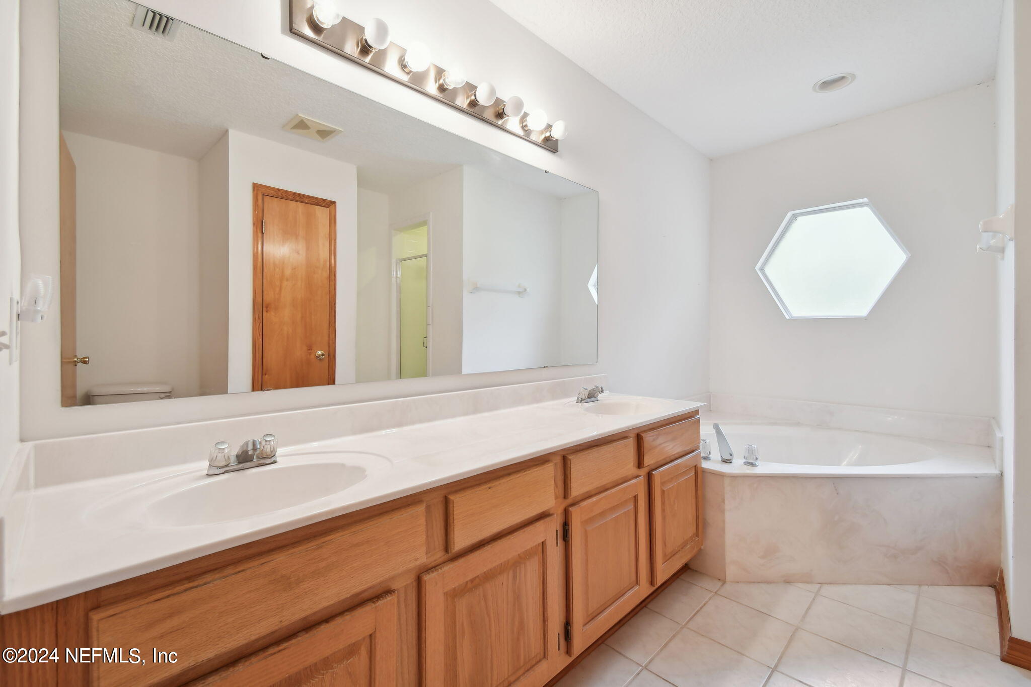 36068 J W Elliott Road Callahan, FL 32011 - Photo 40 of 54 a bathroom with a tub sink and mirror
